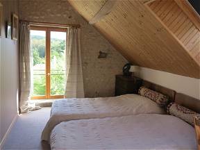 En dormitorio de granja restaurada con vista al valle.